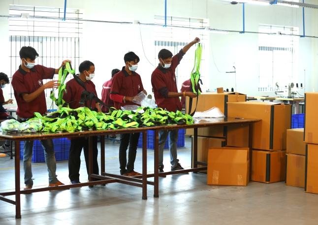 Team inspecting and packing finished harness webbing