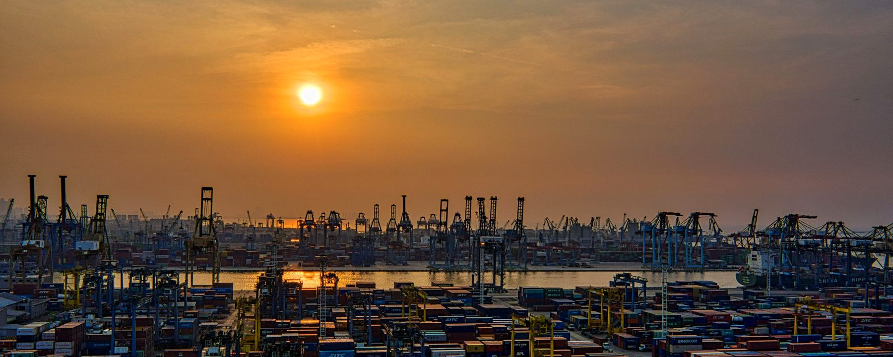 Container terminal at dusk with stacked export containers